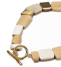 Load image into Gallery viewer, Necklace of different shaped white wooden segments inlaid with mother of pearl and abalone shell and brass