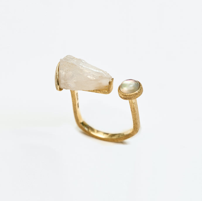 Gold ring with rock crystal and mother of pearl on a white background