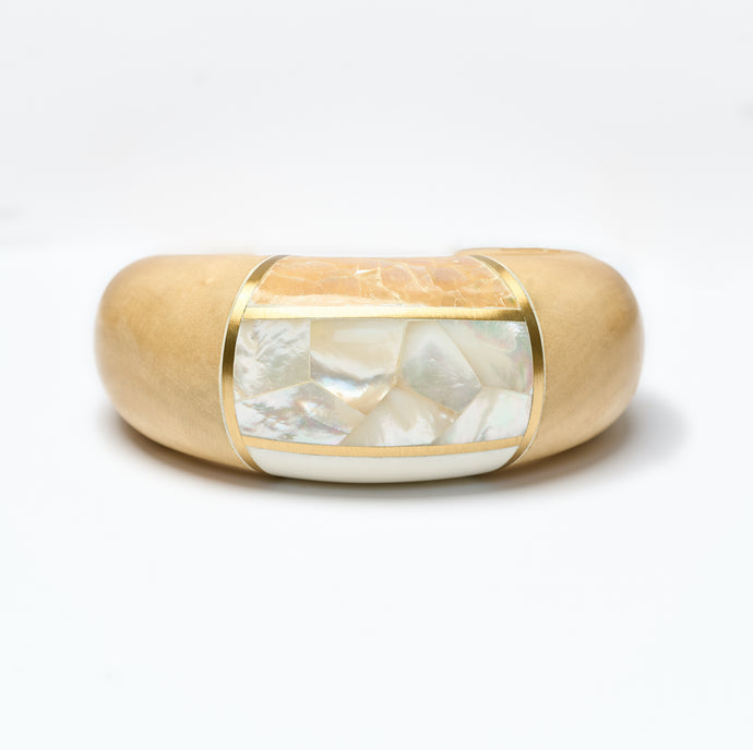 Wooden Cuff bracelet  with a central mother of pearl inlay on a white background