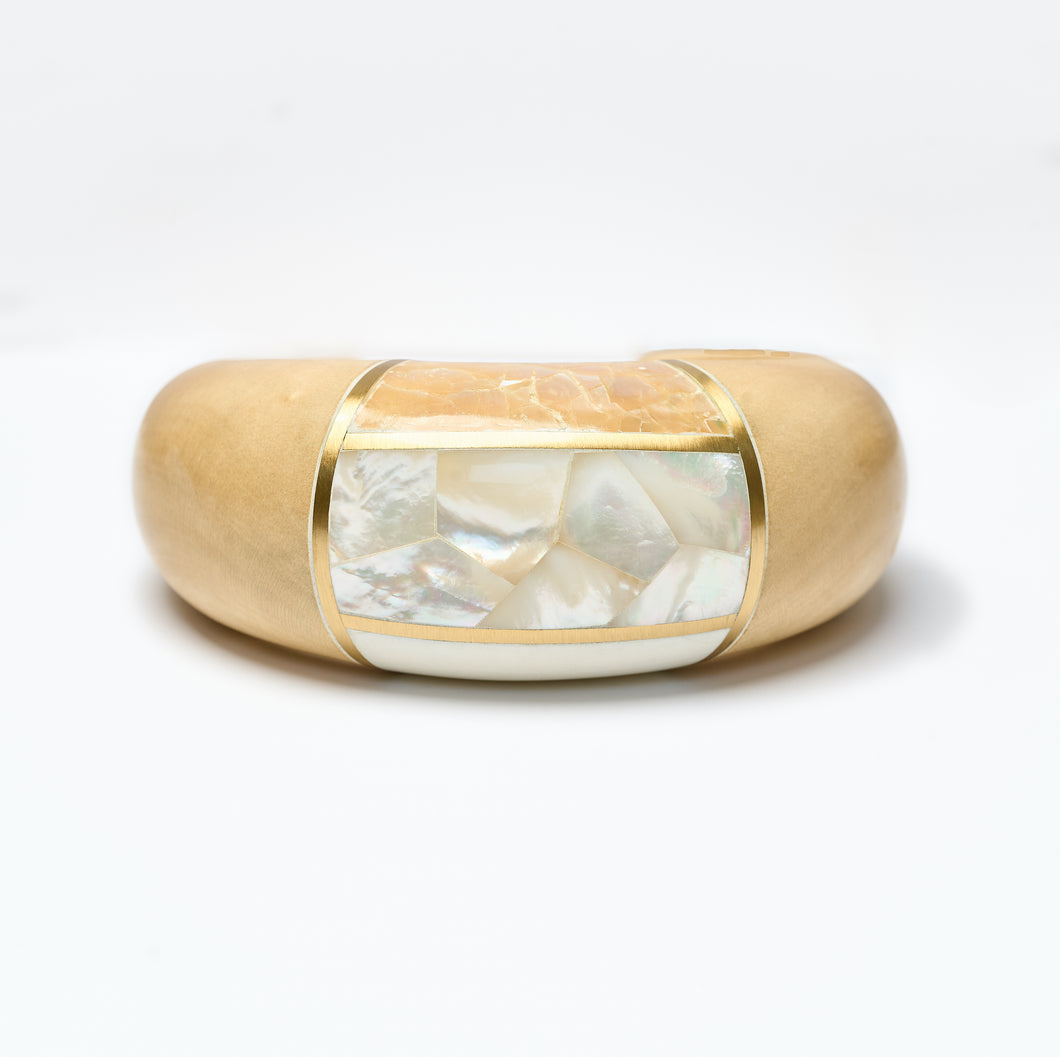 Wooden Cuff bracelet  with a central mother of pearl inlay on a white background